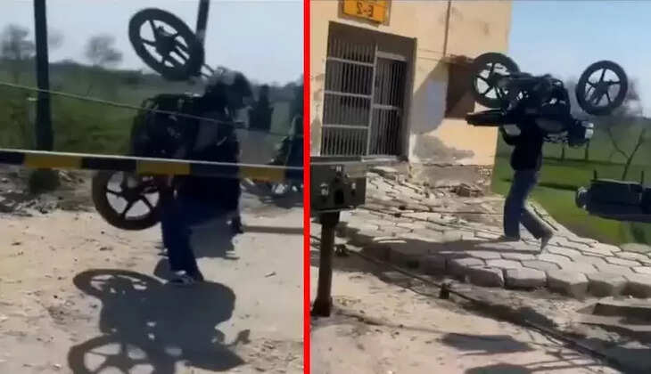 பைக்கை தோளில் சுமந்து ரயில்வே கிராசிங்கை கடந்த நபர்